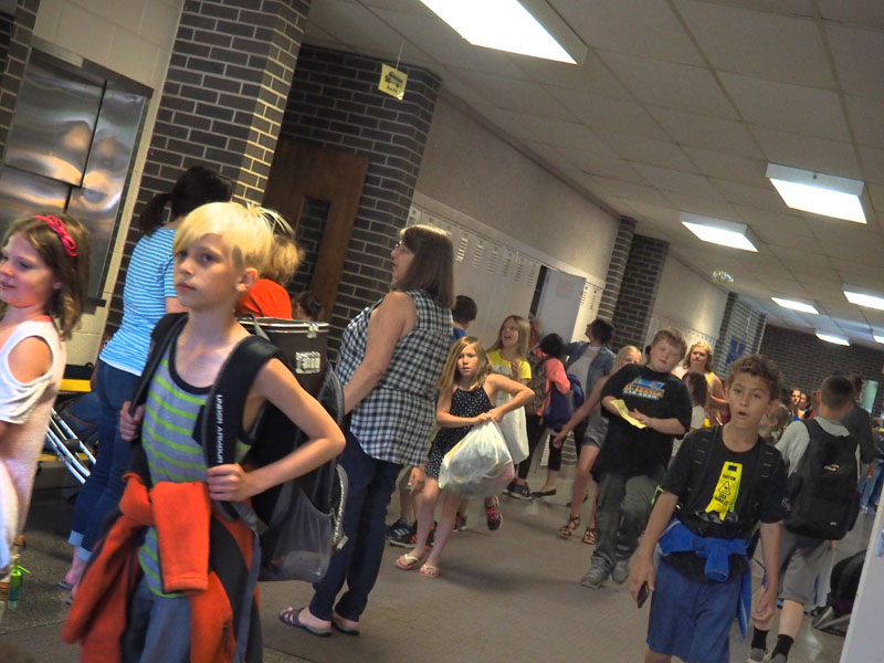 students in hallway at kennedy school, walking towards door