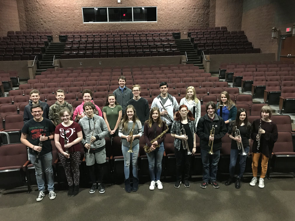Students posing in auditorium with instruments