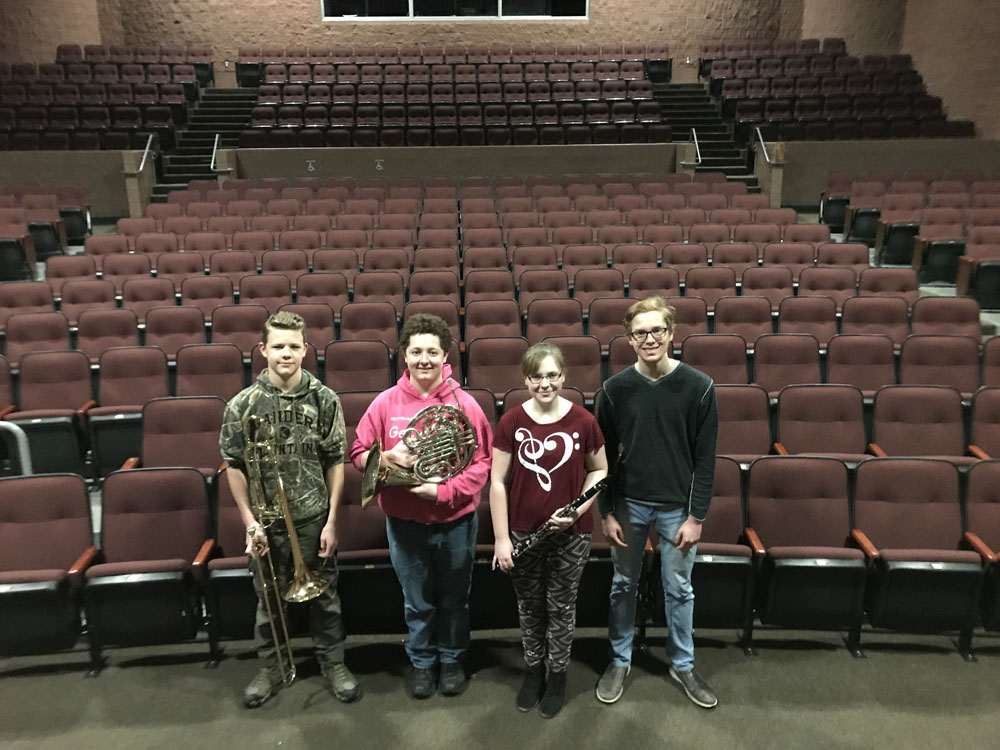 Four students with brass instruments