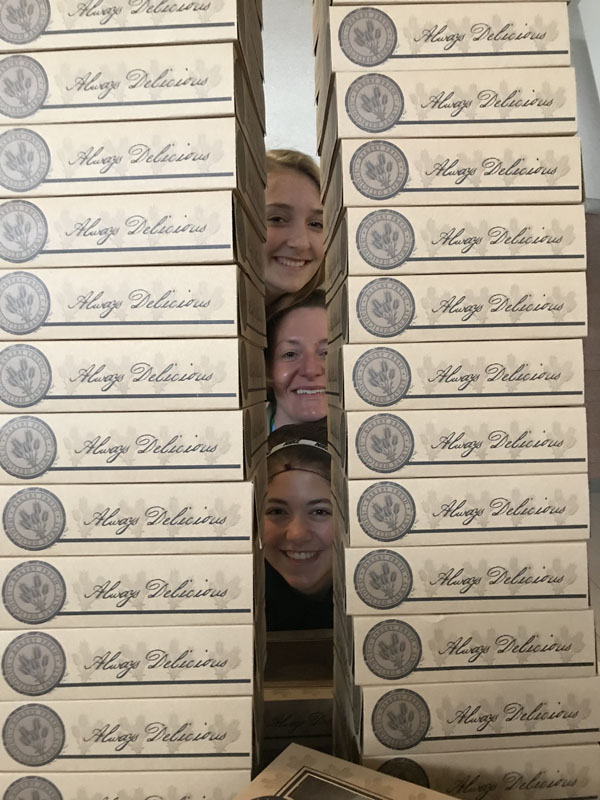 Students peeking through stacks of pies
