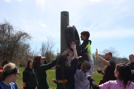 Students helping student climb