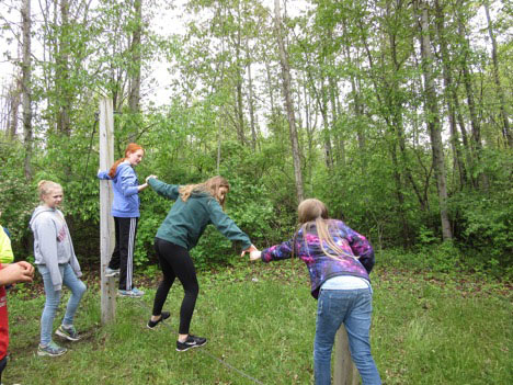 Students assisting each other in crossing wire