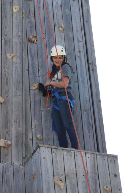 Student looking down from climbing wall