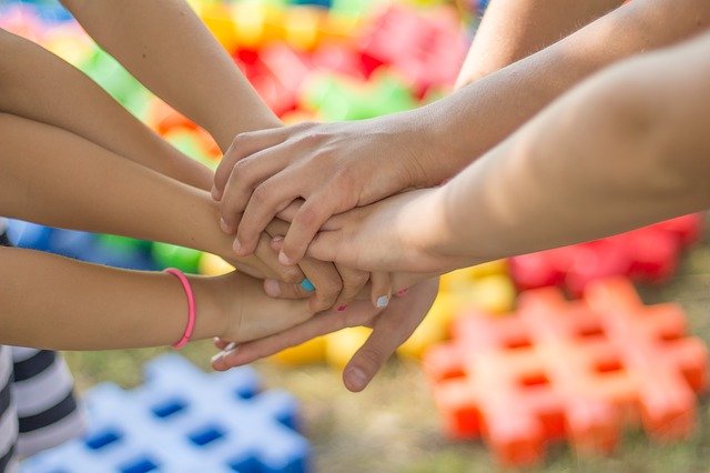 Students hands reaching together