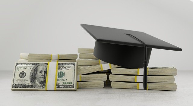 graduation cap on stack of dollars