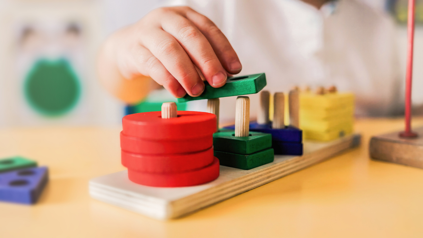 Kid Playing With Wood Toys At Pre School Classroom. Kindergarten Education Smart Games For Children Child stacking rings