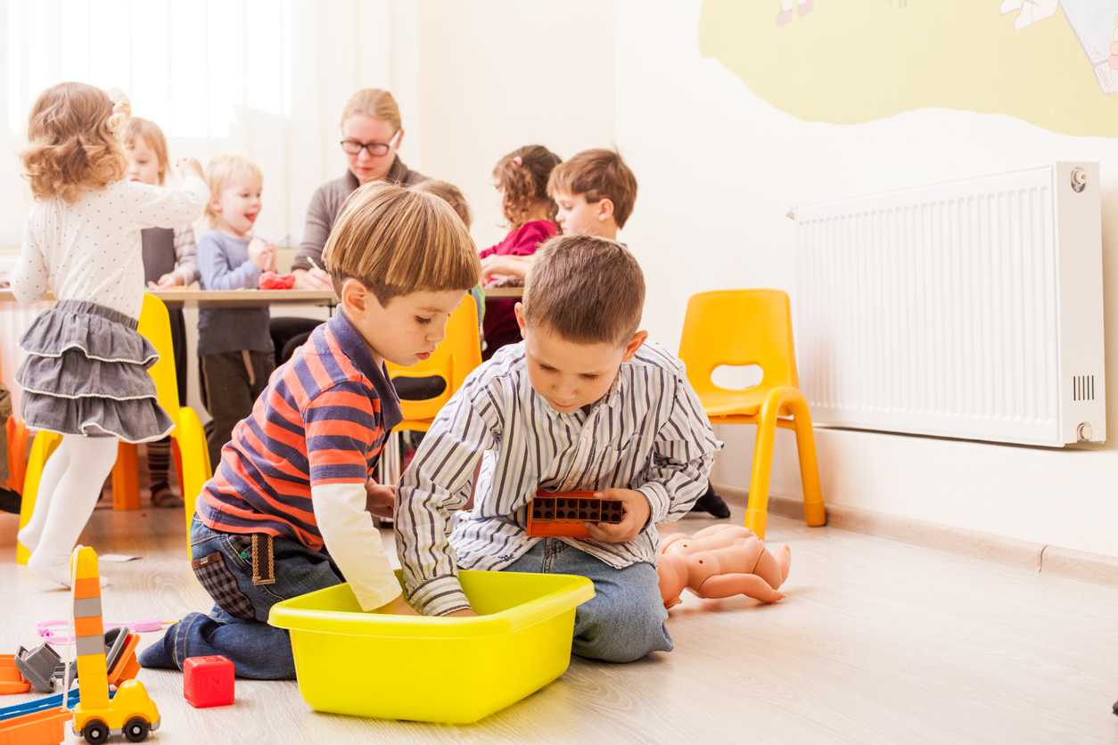Rear View Of People Sitting On Table Boy playing together in a classroom